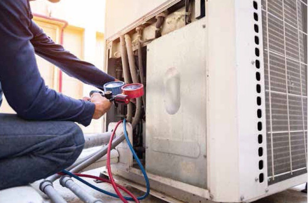 Technician servicing an air-conditioning unit